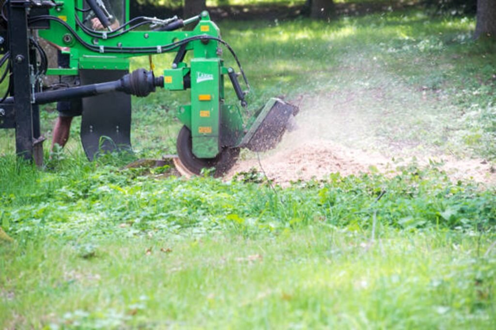 Stump grinding machine removing a tree stump and wood chips in a residential yard in Twinsburg, OH