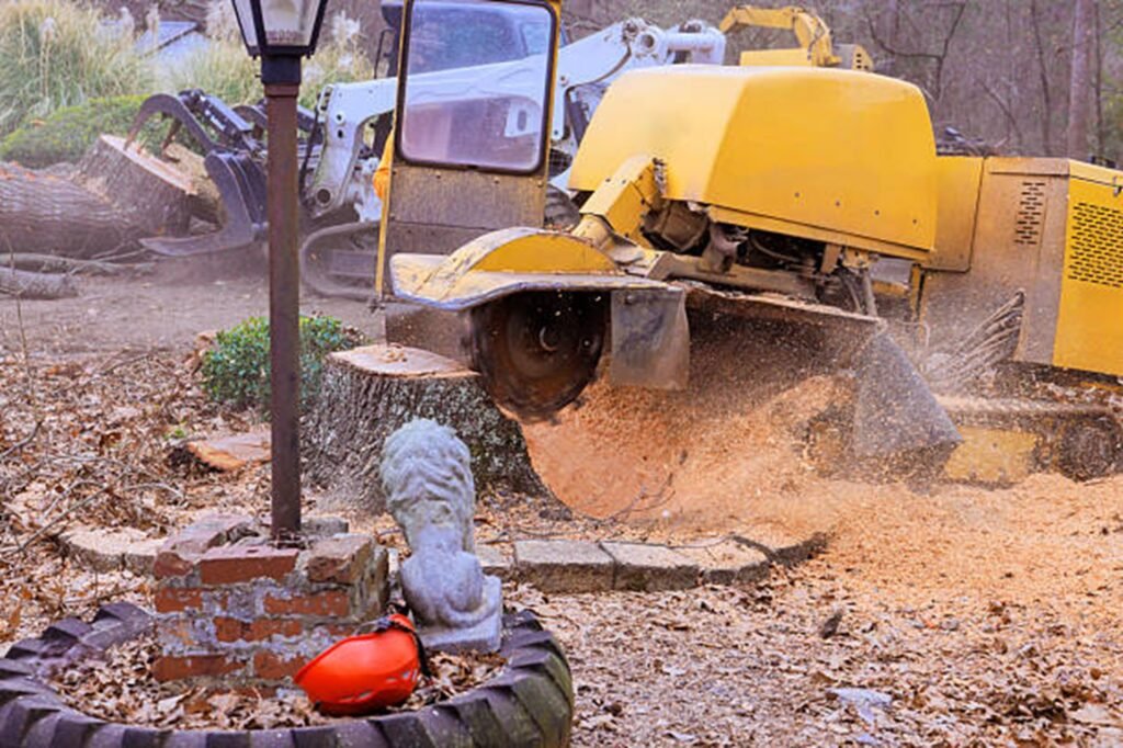 Stump grinding machine removing a large tree stump and wood debris in a residential yard in Twinsburg, OH